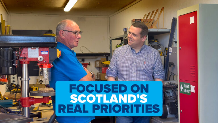 Douglas Ross speaks to an older man wearing glasses. Caption reads 'Focused on Scotland's Real Priorities'.