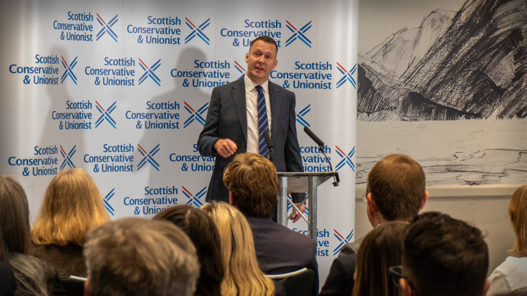 Russell Findlay photographed standing at a podium delivering his first speech as leader of the Scottish Conservatives.